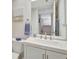 Bright bathroom with white cabinetry, neutral walls, and a large mirror reflecting the hall at 601 Shreve St # 13A, Punta Gorda, FL 33950