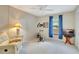 Neutral bedroom features a ceiling fan, blue curtains, fitness machine, and comfortable recliner at 601 Shreve St # 13A, Punta Gorda, FL 33950