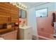 Bathroom with pink tile, sink, cabinet, toilet, wooden cabinet and window at 120 Buckeye Nw Ave, Port Charlotte, FL 33952