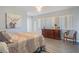 Bedroom with gray floors, dresser, closet with folding doors and a bed with gray and gold bedding at 120 Buckeye Nw Ave, Port Charlotte, FL 33952