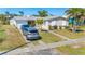 Charming home with mature landscaping, a two-car garage, and a spacious front yard at 120 Buckeye Nw Ave, Port Charlotte, FL 33952