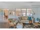 Living room with gray floors, comfortable seating, large window, and view of dining area at 120 Buckeye Nw Ave, Port Charlotte, FL 33952