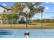 Outdoor basketball court with view of the home, surrounded by lush landscaping and fencing at 13000 Windcrest Dr, Port Charlotte, FL 33953