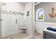 This bathroom has a glass shower with mosaic tile accents, a built-in seat, and an arched window at 13000 Windcrest Dr, Port Charlotte, FL 33953