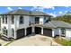 Elegant two-story home boasts a three-car garage and a private balcony overlooking the lush landscaped yard at 13000 Windcrest Dr, Port Charlotte, FL 33953