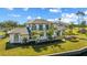 Stunning waterfront home featuring manicured lawn, tropical landscaping, and a rear balcony overlooking the serene waterfront at 13000 Windcrest Dr, Port Charlotte, FL 33953