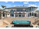 Expansive home showcasing an outdoor lounge with a fire pit and resort-style pool at 13000 Windcrest Dr, Port Charlotte, FL 33953