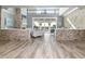 Spacious foyer with stone accent walls, light wood floors and clear view of the outdoor pool at 13000 Windcrest Dr, Port Charlotte, FL 33953