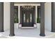 Elegant front entrance with stately pillars, a welcoming double door, and decorative planters at 13000 Windcrest Dr, Port Charlotte, FL 33953