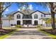 Elegant home exterior showcasing a grand entrance, manicured landscaping, and a circular driveway at 13000 Windcrest Dr, Port Charlotte, FL 33953