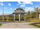 Charming gazebo nestled in lush landscaping with a concrete pathway leading to it at 13000 Windcrest Dr, Port Charlotte, FL 33953