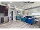This spacious living room features wood-look tile flooring, a wet bar, and comfortable blue seating at 13000 Windcrest Dr, Port Charlotte, FL 33953