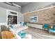 Bright living room boasts a stone accent wall, large windows with a view of the pool, and comfortable seating at 13000 Windcrest Dr, Port Charlotte, FL 33953