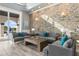 Inviting living room with stone accent wall, wood-look tile flooring, and view to the pool at 13000 Windcrest Dr, Port Charlotte, FL 33953