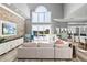 Bright living room boasts a stone accent wall, large windows with a view of the pool, and comfortable seating at 13000 Windcrest Dr, Port Charlotte, FL 33953