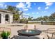 Inviting patio with a modern fire pit, comfortable seating, and serene outdoor views at 13000 Windcrest Dr, Port Charlotte, FL 33953