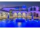 Beautiful pool with in-pool seating, umbrellas and an arched porch overlooking the backyard at 13000 Windcrest Dr, Port Charlotte, FL 33953