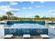 Sparkling blue tiled pool with a sun shelf and waterfall features surrounded by palms at 13000 Windcrest Dr, Port Charlotte, FL 33953