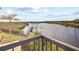 Scenic waterfront view showcases a private dock and boathouse, complemented by lush landscaping and a serene atmosphere at 13000 Windcrest Dr, Port Charlotte, FL 33953