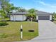Charming one-story home with a well-manicured lawn and mature palm trees. Attached two-car garage and fresh landscaping at 1301 Appian Dr, Punta Gorda, FL 33950