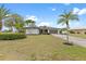 Well-maintained home featuring a lush front yard with palms and lovely landscaping at 1301 Appian Dr, Punta Gorda, FL 33950