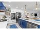 Modern kitchen with white cabinetry, stainless appliances, and a stylish blue accent hood at 1301 Appian Dr, Punta Gorda, FL 33950