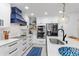 Modern kitchen with white cabinetry, stainless appliances, and a stylish blue accent hood at 1301 Appian Dr, Punta Gorda, FL 33950
