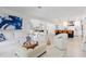 Open-concept living room with white furniture, tile flooring, and a view into the dining and kitchen areas at 1301 Appian Dr, Punta Gorda, FL 33950