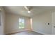 Well-lit bedroom with light walls, wood-look tile flooring, a ceiling fan, and a window at 18098 Petoskey Cir, Port Charlotte, FL 33948