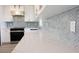 Close-up of the kitchen's quartz countertops and stylish blue tile backsplash at 18098 Petoskey Cir, Port Charlotte, FL 33948