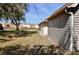 Backyard view featuring a small building, grass lawn, and exterior wall of main home at 19231 Baoy Ave, Port Charlotte, FL 33948