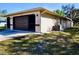 Low angle view of the exterior of this home featuring a garage and lawn at 19231 Baoy Ave, Port Charlotte, FL 33948