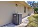 A tan home's exterior showcases the AC unit, walls, small window, and door at 19231 Baoy Ave, Port Charlotte, FL 33948