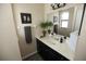 Well-lit bathroom with a sleek black vanity, a white countertop, and decorative plants, blending functionality with style at 2000 Forrest Nelson Blvd # B4, Port Charlotte, FL 33952