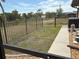 View of the back yard and fence from inside the screened in porch at 21363 Cottonwood Ave, Port Charlotte, FL 33952