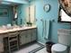 Bathroom features blue walls, a mirror, vanity, toilet, and shower at 21363 Cottonwood Ave, Port Charlotte, FL 33952