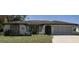 Charming single-story home featuring a stone accent wall, arched entryway, and well-manicured lawn at 21363 Cottonwood Ave, Port Charlotte, FL 33952