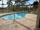 An outdoor pool, complete with a screened-in enclosure, offers serene views at 21363 Cottonwood Ave, Port Charlotte, FL 33952