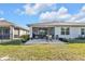 The home's backyard shows a screened patio with outdoor furniture, shrubs, and a green lawn at 25120 E Lenox Cir, Punta Gorda, FL 33950