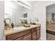 Bathroom featuring double sinks, granite countertops, and a decorative mirror at 25120 E Lenox Cir, Punta Gorda, FL 33950
