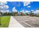Community center and parking area with well-manicured landscaping and blue skies at 25120 E Lenox Cir, Punta Gorda, FL 33950