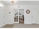 Bright foyer with neutral tile floors and views into a cozy room through glass french doors at 25120 E Lenox Cir, Punta Gorda, FL 33950