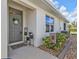 Inviting entrance with decorative details and a 'Welcome' mat, complemented by lush greenery at 25120 E Lenox Cir, Punta Gorda, FL 33950