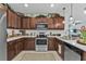 A modern kitchen featuring wooden cabinets, stainless steel appliances, and white quartz countertops at 25120 E Lenox Cir, Punta Gorda, FL 33950