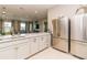 Modern kitchen featuring stainless steel appliances and sleek countertops that open up to the living room at 25120 E Lenox Cir, Punta Gorda, FL 33950