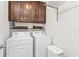 Convenient laundry room with upper cabinets and modern washer and dryer units at 25120 E Lenox Cir, Punta Gorda, FL 33950