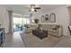 Bright living room featuring a large sectional sofa, ceiling fan, and sliding glass doors to outdoor patio at 25120 E Lenox Cir, Punta Gorda, FL 33950