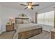 Cozy main bedroom with warm lighting, ceiling fan, and large window at 25120 E Lenox Cir, Punta Gorda, FL 33950