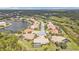 Aerial view of a community featuring tile roofs, serene lakes, and lush green surroundings at 2892 Myakka Creek Ct, Port Charlotte, FL 33953