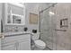 Modern bathroom with gray tile shower, glass doors, white vanity with marble countertop, and decorative elements at 2892 Myakka Creek Ct, Port Charlotte, FL 33953